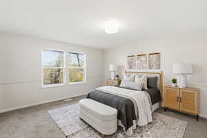 Bedroom featuring light colored carpet and baseboards