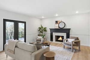 Living area featuring light wood finished floors, a premium fireplace, and recessed lighting