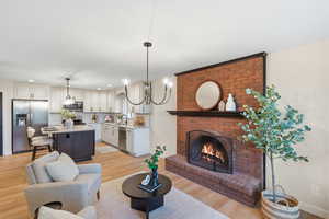 Living area featuring light wood finished floors, a fireplace, and recessed lighting