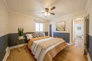 Bedroom featuring light wood-style flooring, ornamental molding, and ceiling fan