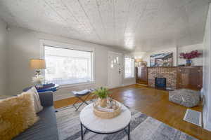Living area featuring wood finished floors and a brick fireplace