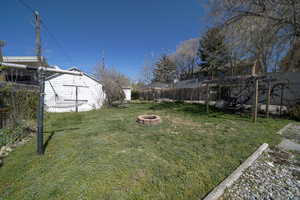 Fenced backyard featuring an outdoor fire pit