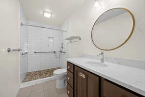Bathroom featuring vanity, a stall shower, and light tile patterned floors