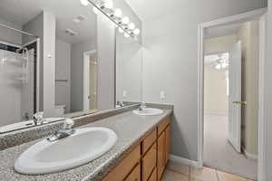 Full bathroom with a shower, double vanity, light carpet, and light tile patterned floors