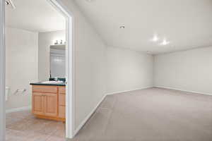Bonus room featuring light carpet and light tile patterned floors