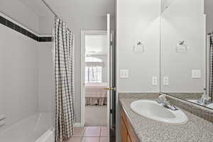 Full bathroom featuring vanity, shower / tub combo, connected bathroom, and light tile patterned floors