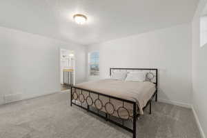 Primary bedroom featuring light carpet and ensuite bathroom
