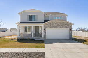 View of front of home with a rock and siding exterior, and a covered front porch