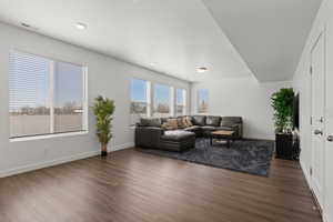 Large open concept living room featuring ample windows, 9' ceilings, and LVP flooring