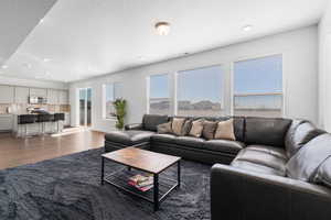 Large open concept living room featuring ample windows, 9' ceilings, and LVP flooring