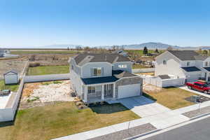 View of front of property with covered porch, vinyl fencing, and partial landscaping