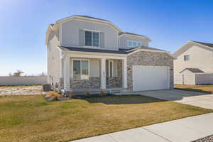 View of front of home with a rock and siding exterior, and a covered front porch