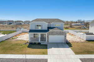 View of front of property with covered porch, vinyl fencing, and partial landscaping