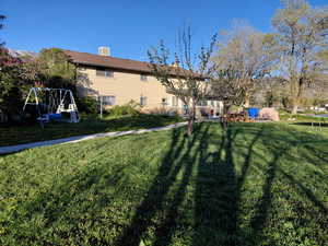 South side of home featuring a sunroom and a large yard.
