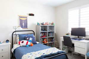 Carpeted bedroom with a desk