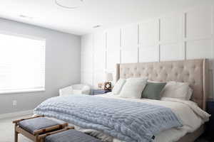 Bedroom with a decorative wall and carpet floors