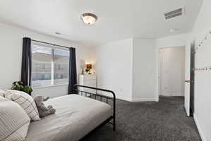Bedroom featuring dark carpet and a textured ceiling