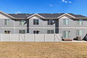 Back of house with a gate, a patio, and stucco siding