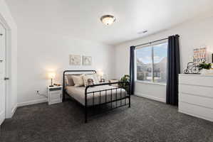 Bedroom featuring dark colored carpet