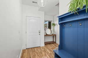 Mudroom with light wood finished floors and baseboards