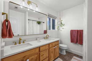 Full bathroom with double vanity and a shower with curtain