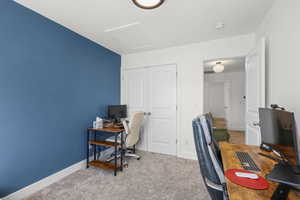 Carpeted office with attic access and baseboards