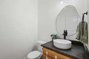 Half bathroom with vanity and toilet