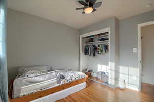 Bedroom featuring a closet, wood finished floors, and a ceiling fan