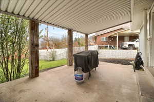 Fenced backyard with a patio and area for grilling