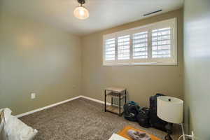 Spare room with dark colored carpet and baseboards