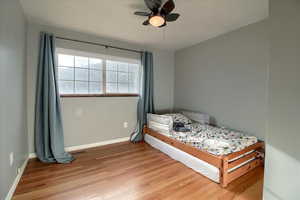 Bedroom with light wood finished floors and a ceiling fan