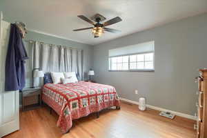 Bedroom with light wood finished floors and a ceiling fan
