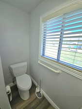 Primary Bathroom featuring grab bar and dark wood-style flooring