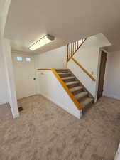 Front entrance and Stairs featuring carpet floors and a textured ceiling