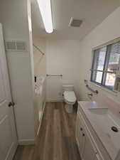 Full bath featuring vanity, dark wood-style floors, and washtub / shower combination