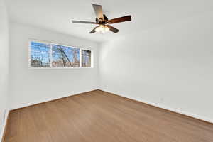 Unfurnished room with a ceiling fan and light wood-type flooring