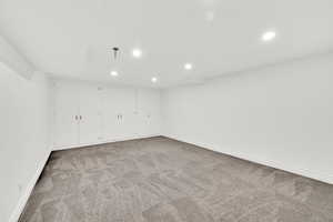 Finished below grade area with light carpet and recessed lighting