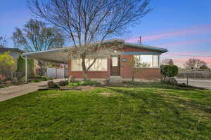 View of front of house with a carport, driveway, and brick siding