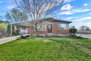 View of front of home featuring a carport, brick siding, and concrete driveway