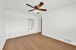 Unfurnished bedroom featuring light wood-type flooring, ceiling fan, and a closet