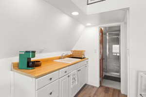 Full bath featuring vanity, dark wood-style flooring, recessed lighting, a shower stall, and lofted ceiling