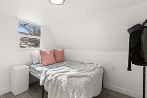 Bedroom with wood finished floors and vaulted ceiling
