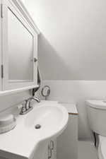 Bathroom with vanity and lofted ceiling