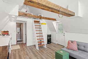 Additional living space featuring vaulted ceiling, light wood finished floors, and recessed lighting