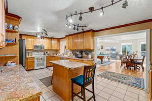 Kitchen with, light tile patterned floors, a textured ceiling, stainless steel appliances, and open shelves