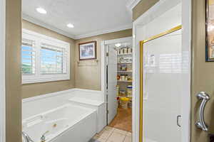 Full bathroom featuring crown molding, a tub with jets, a stall shower, a textured ceiling, and light tile patterned floors
