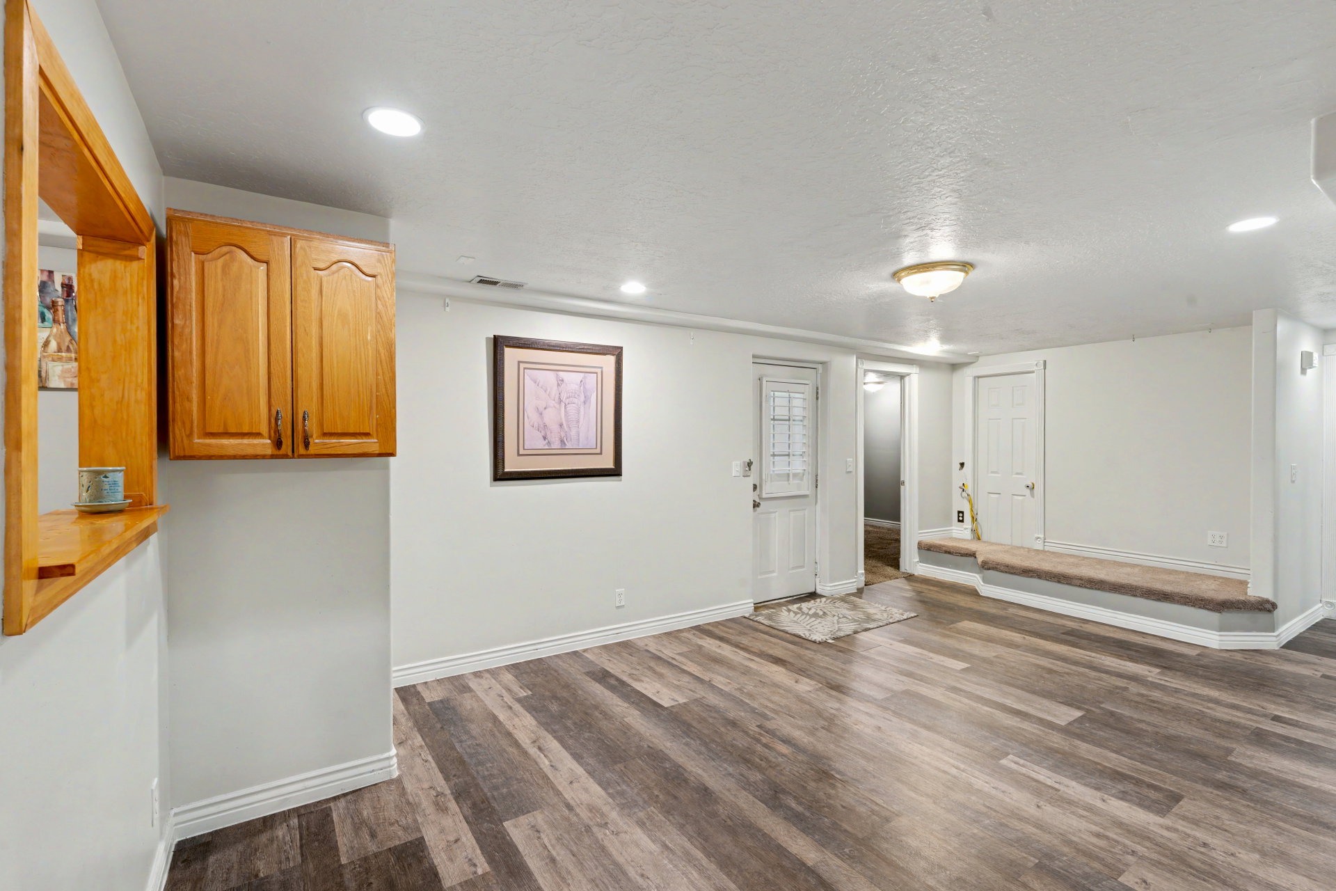 Downstairs kitchen/dining unfurnished living room featuring dark wood finished floors, recessed lighting, and a textured ceiling