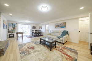 Living area with recessed lighting and light wood-style flooring