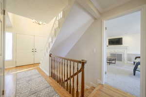 Foyer featuring light wood-type flooring, ornamental molding, and a chandelier