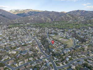 Aerial overview of property's location with a mountain backdrop and nearby suburban area